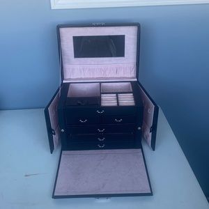 Black leather type material jewelers box. Pink soft interior.